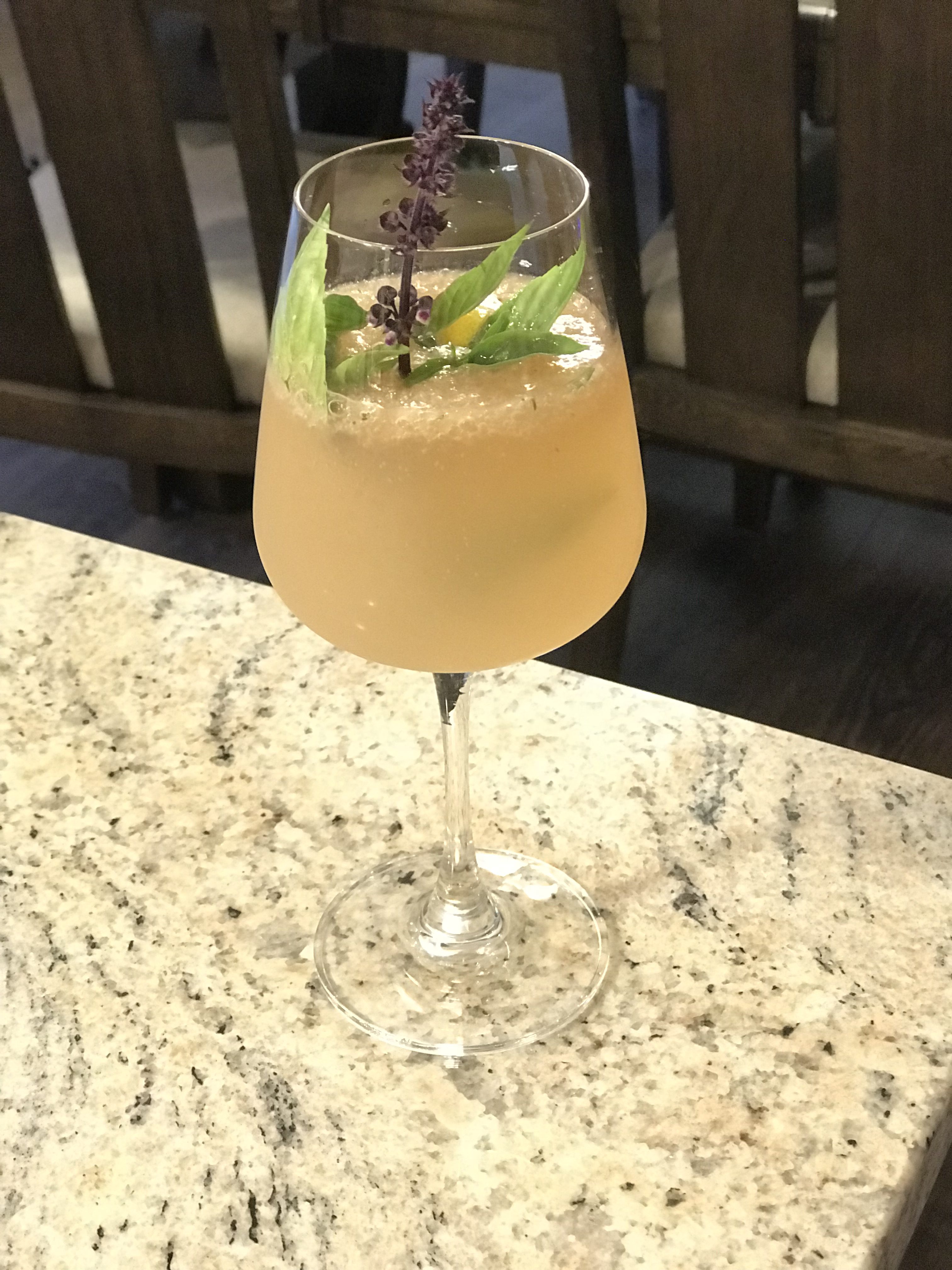 Rhubarb cocktail with Hendrick's gin, lemon, lime juice, rhubarb jam, English thyme, ginger beer, and Thai basil.